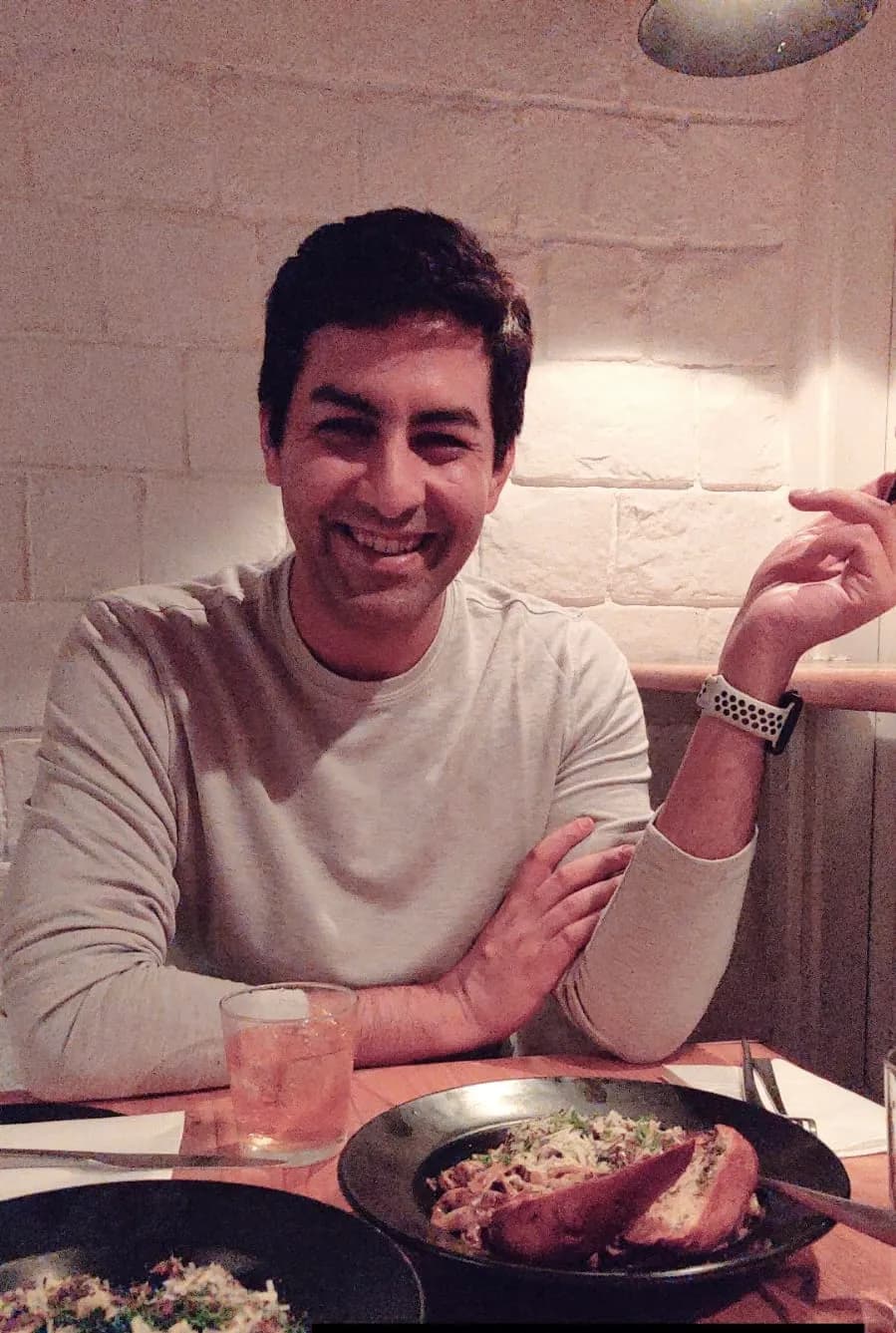 Abhay smiling at a restaurant table