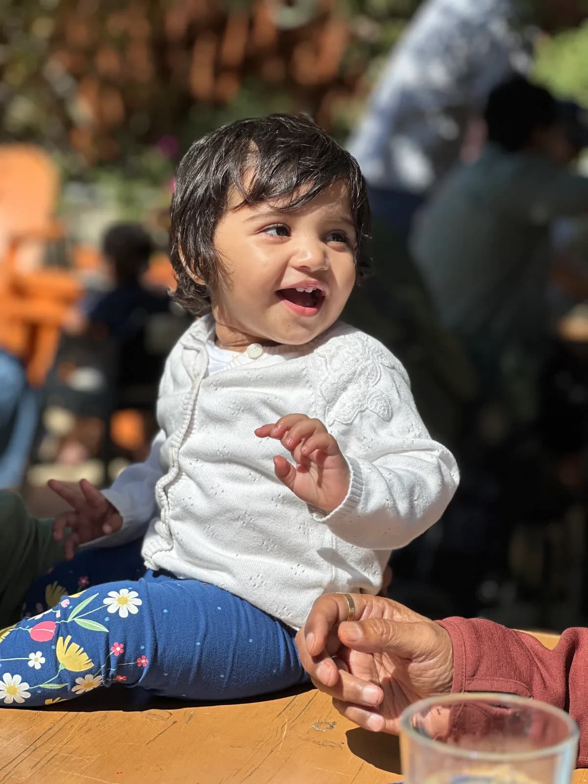 Toddler laughing at a wooden table