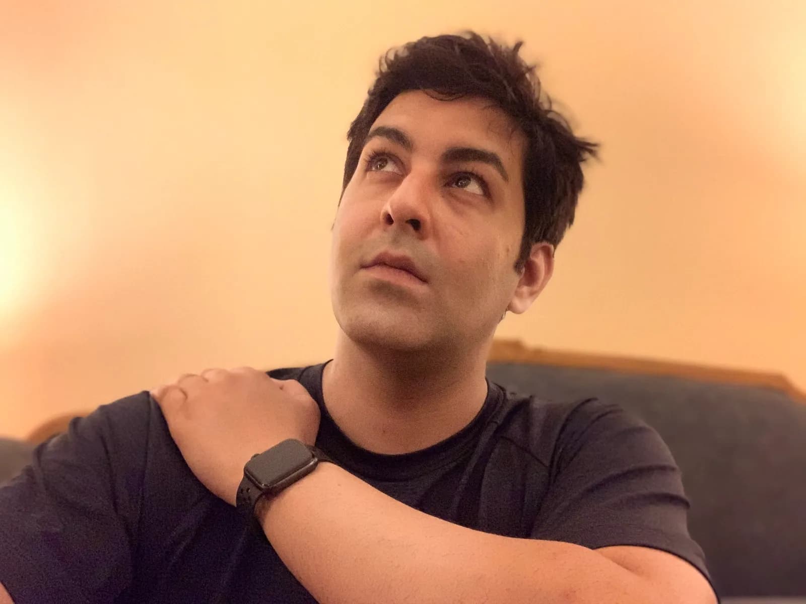 Abhay on a sofa, looking up and thinking